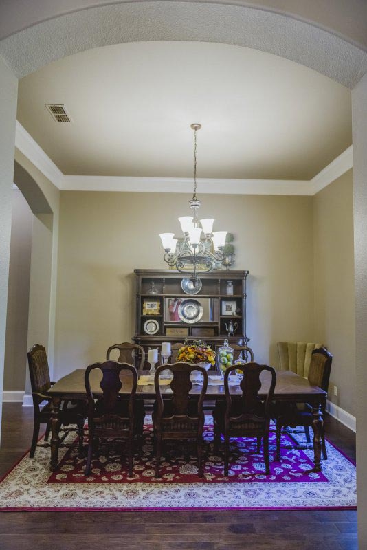 Formal Dining with arched openings stacked Crown molding and Wood floor