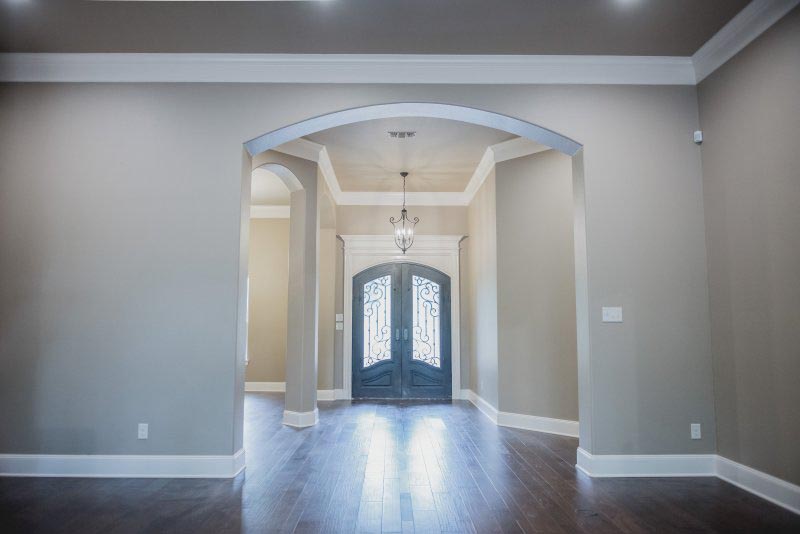 Iron Door Entry with Custom Trim casings and Wood Floors